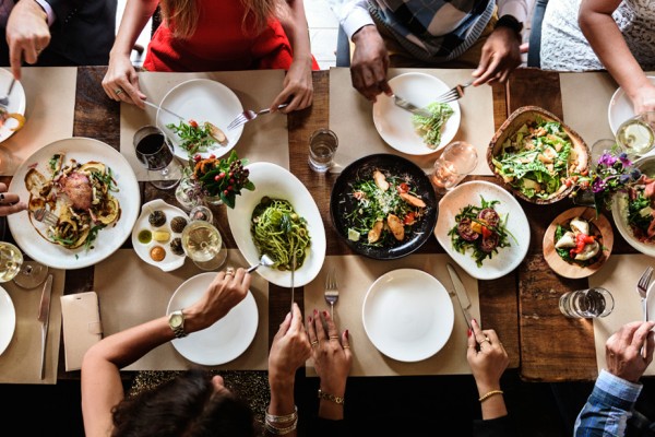Friends gather for a meal around a table 