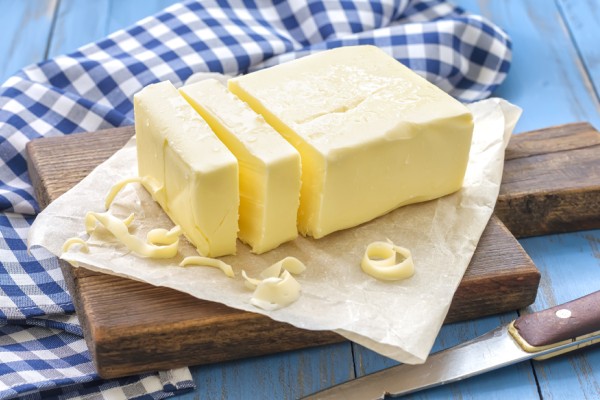 Butter block beside measuring tools showing volume and weight conversions