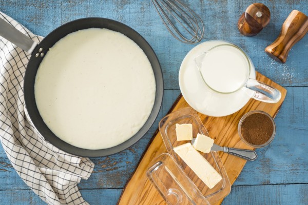 Creamy basic white sauce simmering in a pan, made with Canadian butter and milk 