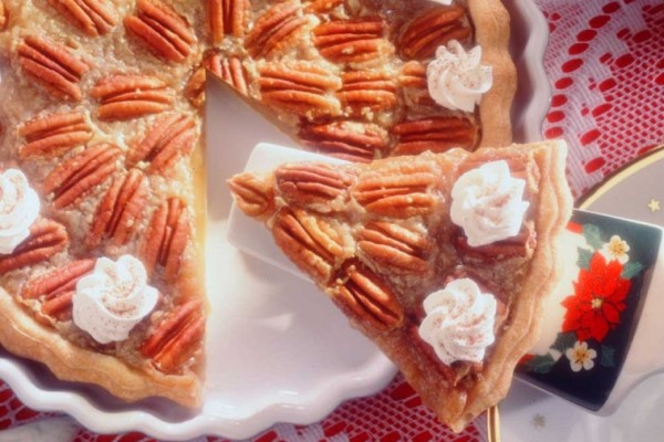 Slice of pecan sugar pie with a flaky crust, sweet pecan topping, and creamy filling.