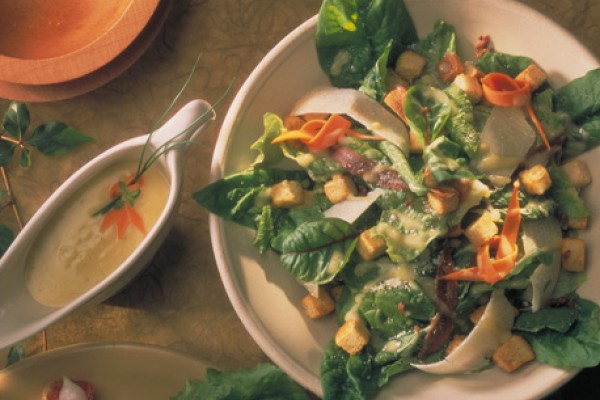 Plate of spinach and croutons with caesar salad dressing 