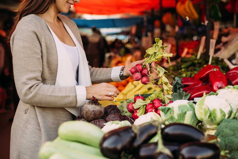 Woman buying produce at farmer’s market.