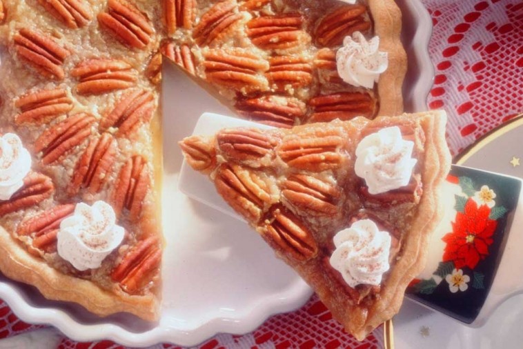 Slice of pecan sugar pie with a flaky crust, sweet pecan topping, and creamy filling.